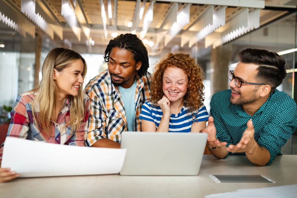 a group of people looking at a laptop