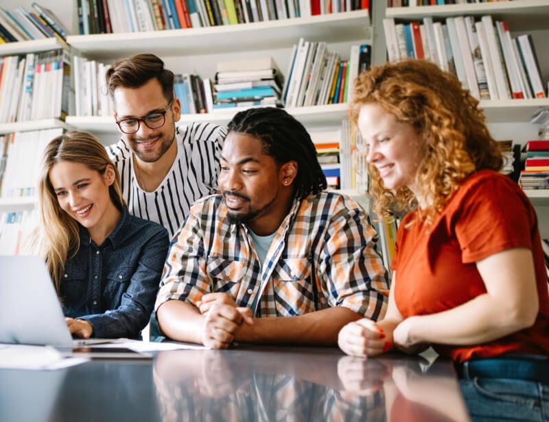 a group of people looking at a laptop