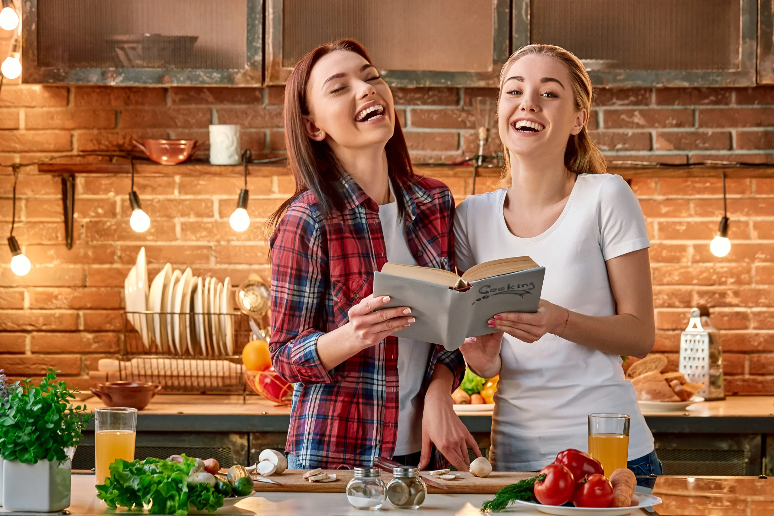 Eat to live, don t live to eat. Young female friends preparing together healthy meal in modern